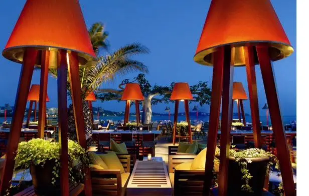Mojito Bay lighting design — seaside bar in Greece with sculptural illuminated lamp totems at blue hour
